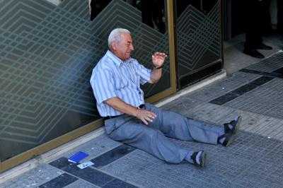 Vede foto pensionato greco davanti alla banca, uomo d'affari australiano lo aiuta